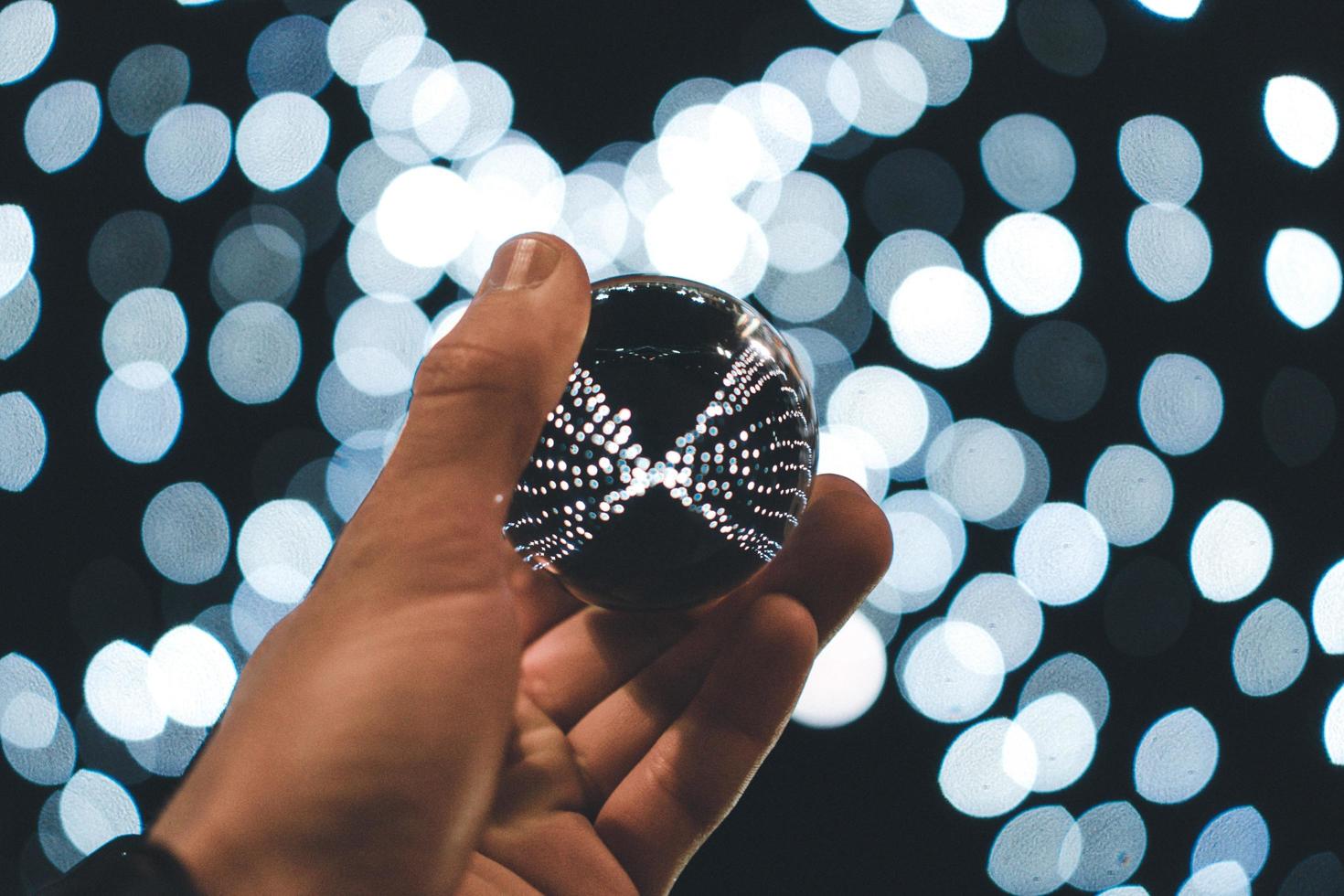 person holding silver ball with bokeh background photo
