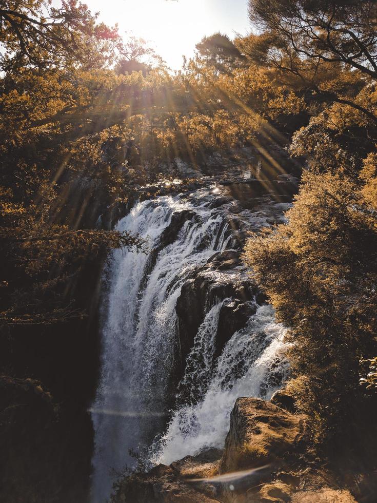 Waterfall among rocks and trees photo