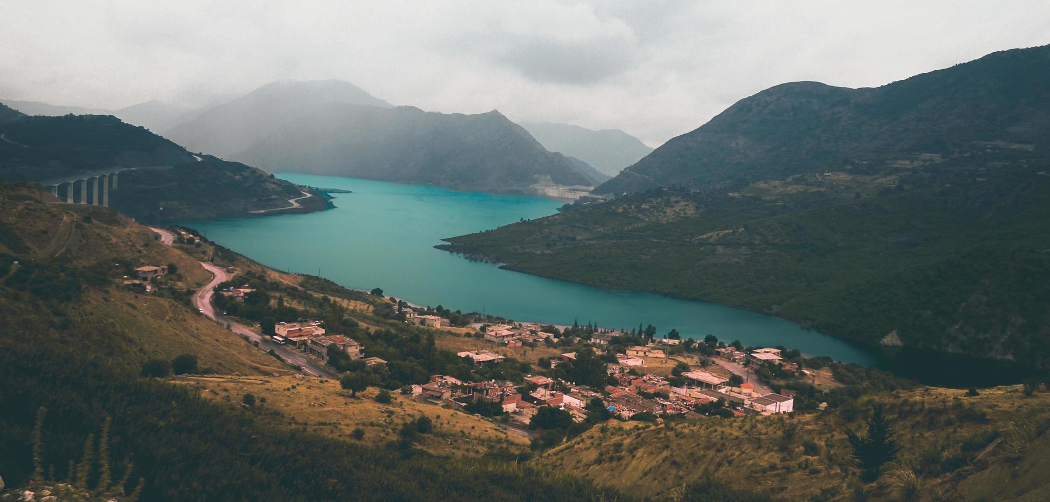 Aerial view of houses and mountains beside lake photo