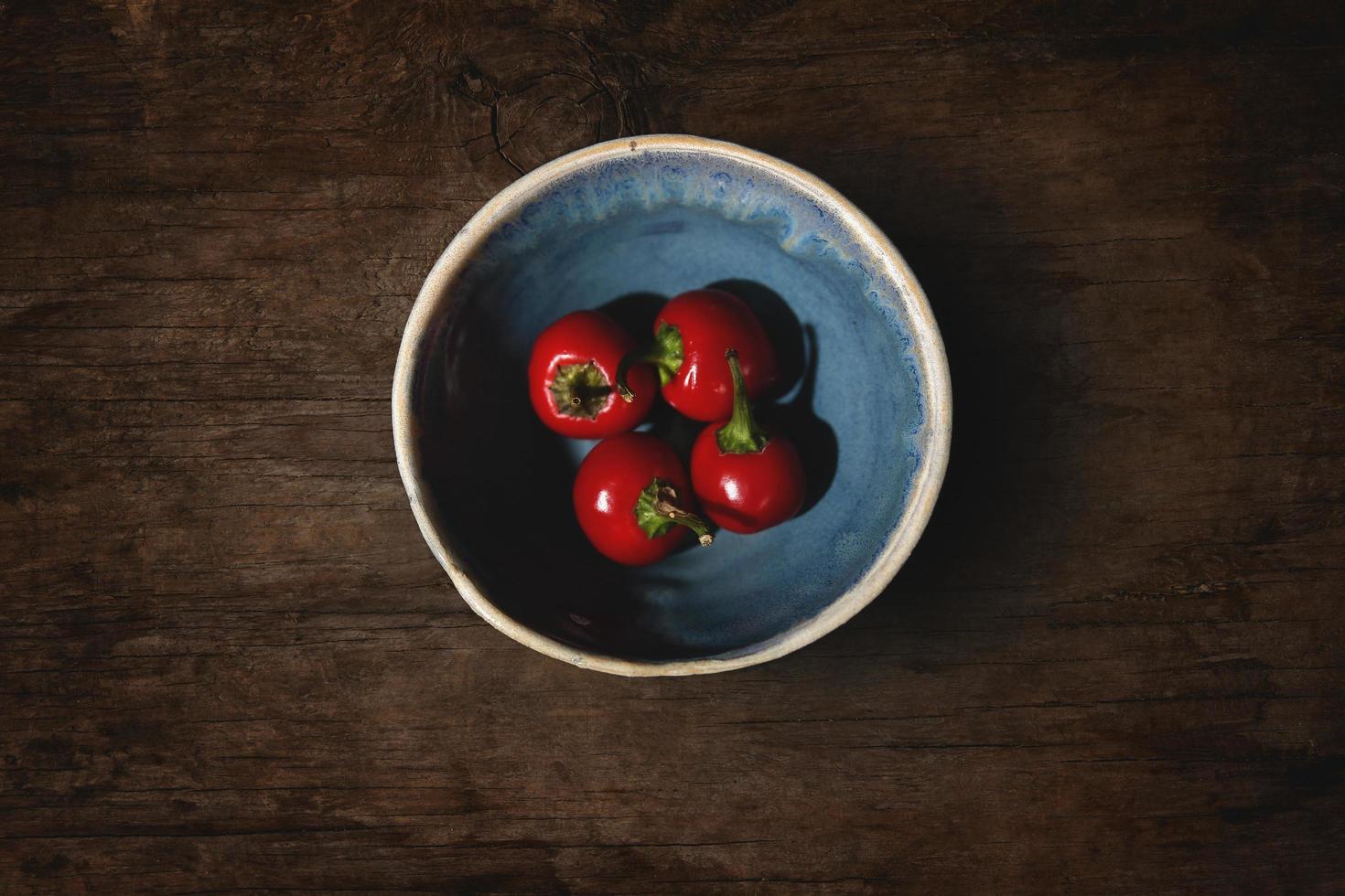 Red cherries in bowl on wooden table photo