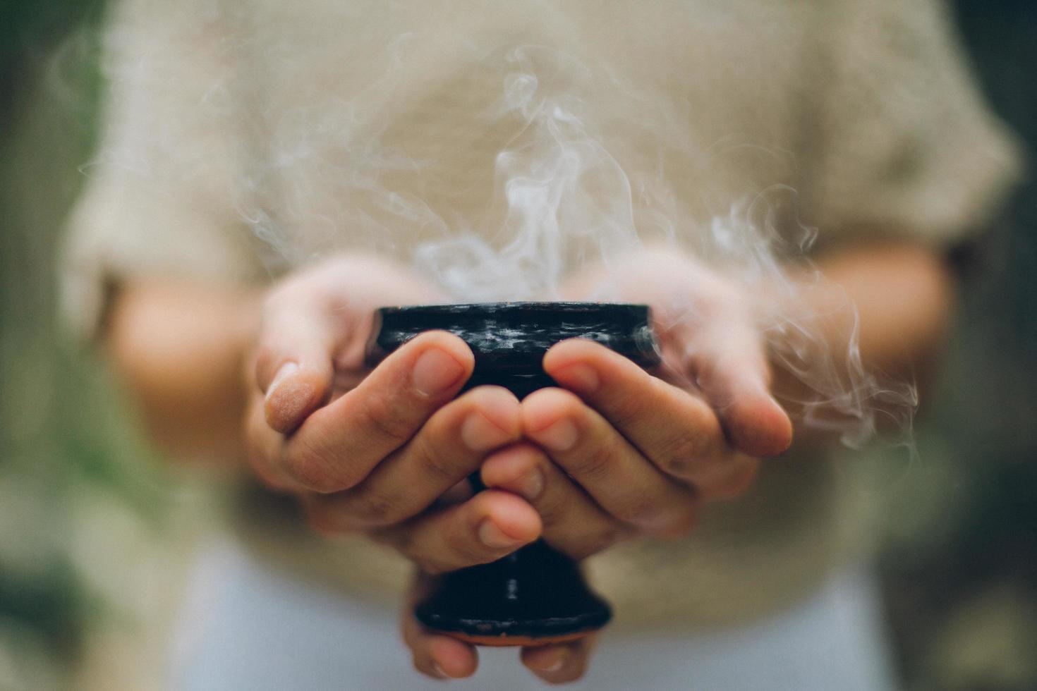 Hands holding bowl filled with smoke photo