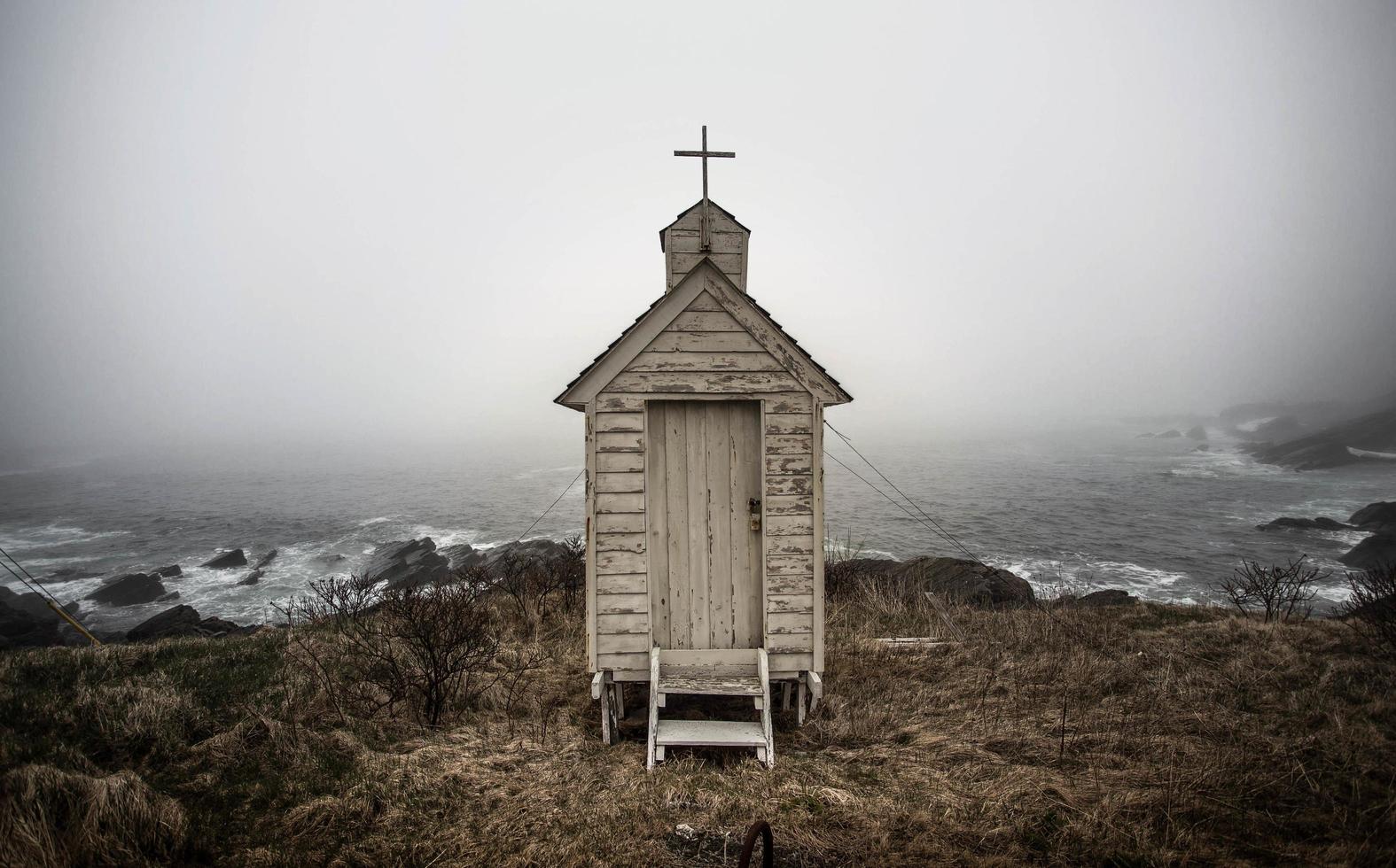 Gray wooden shed on cliff photo