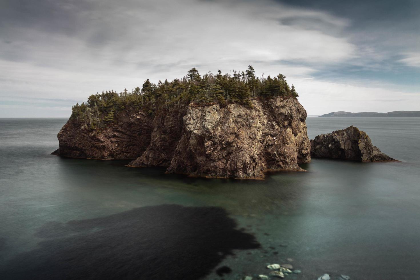 Brown rock formation in body of water photo