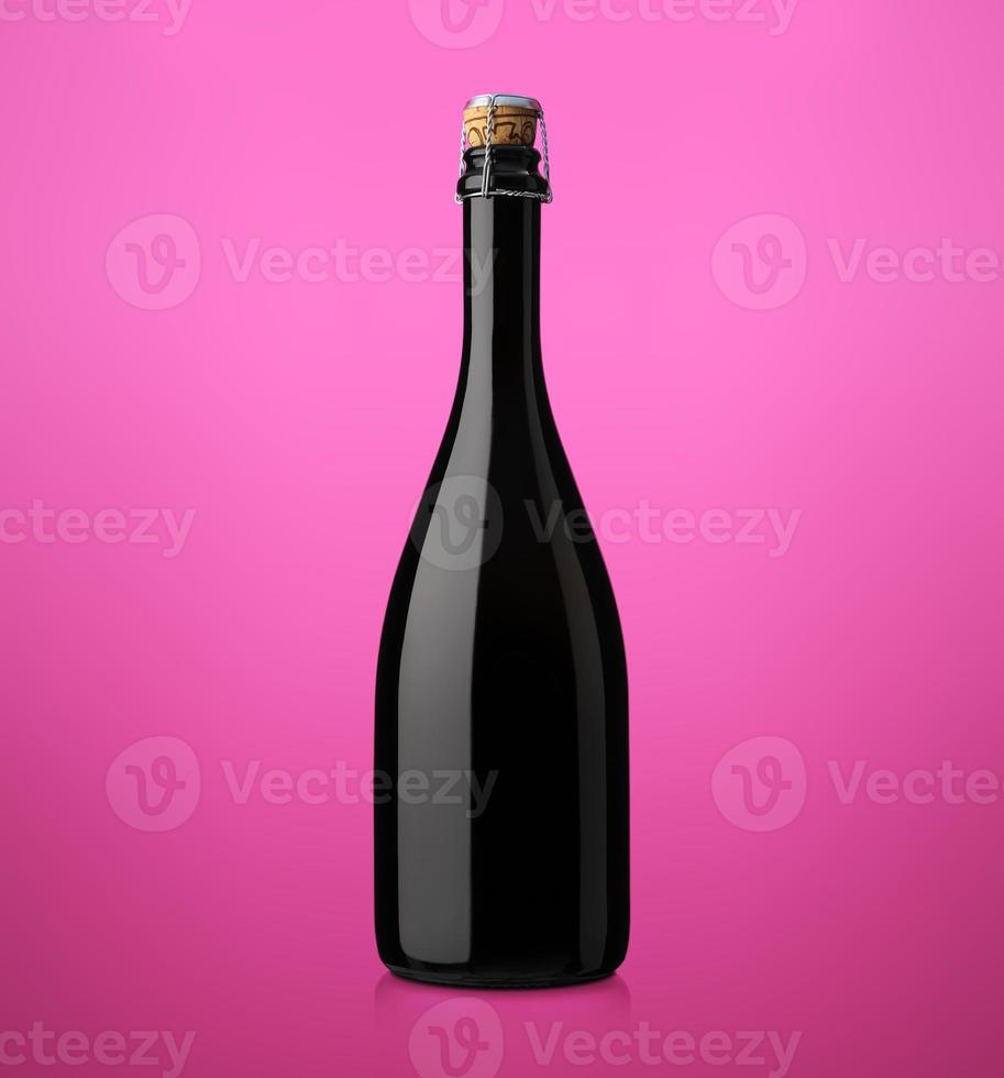 Botella de vino espumoso con corcho sobre un fondo de color foto