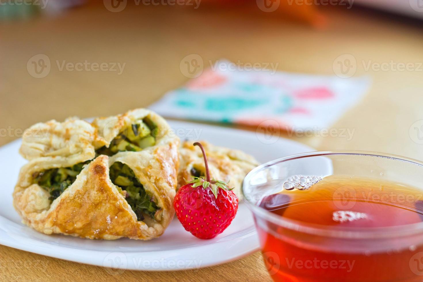 Fresh baked homemade puff pastry cakes with cup of tea photo