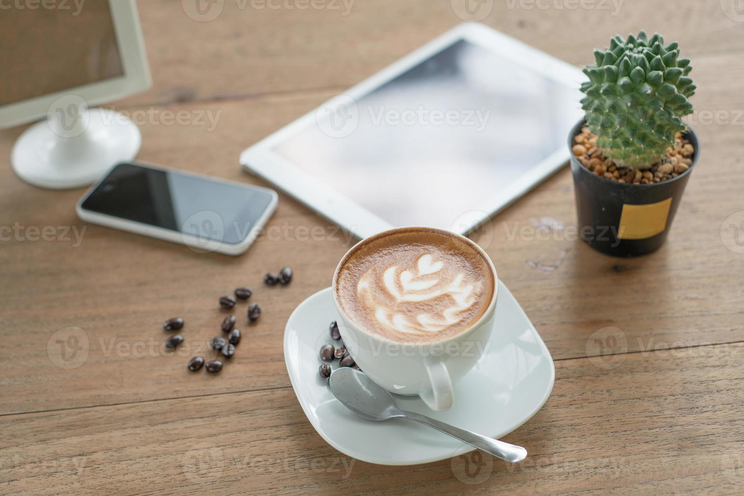 A cup of cappuccino, coffee and breakfast pastries on a wooden table with a  laptop computer for work and accessories. Generative AI Stock Photo