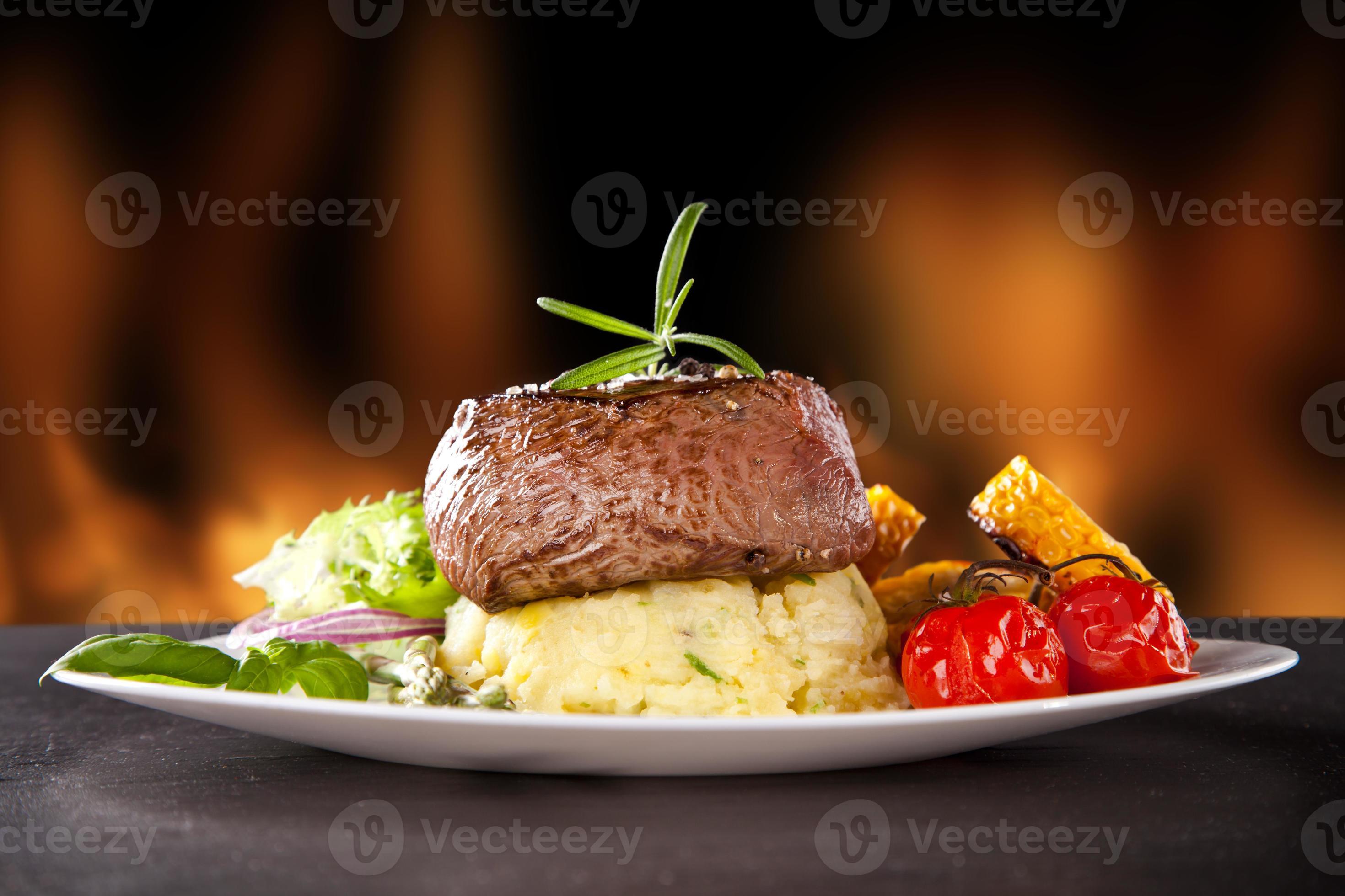 Fresh beef steak on black stone and fire photo