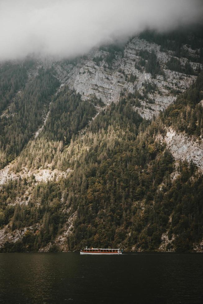 Boat moving along river near mountain photo