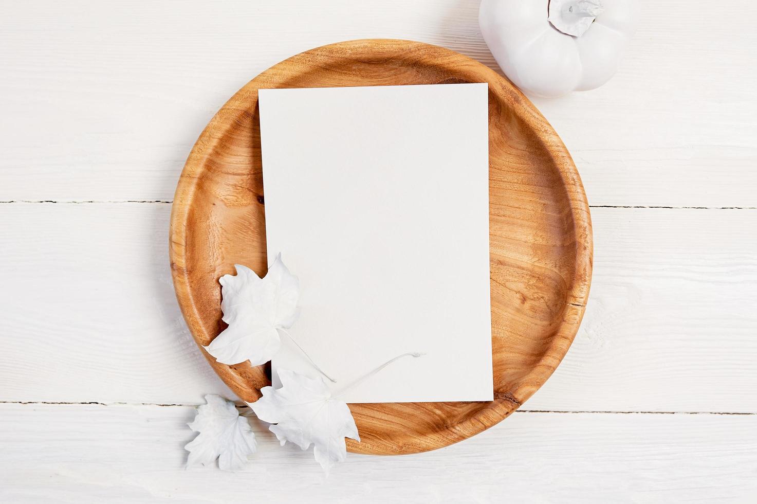 plato de madera con hoja de papel blanco foto