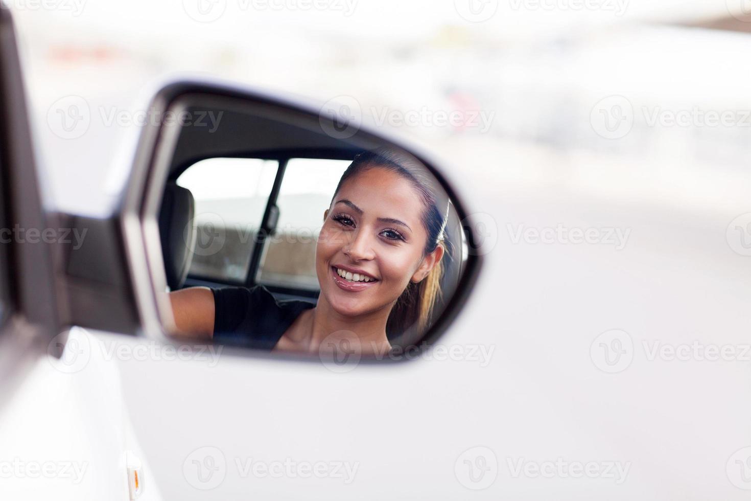 young businesswoman driver looking at side mirror photo