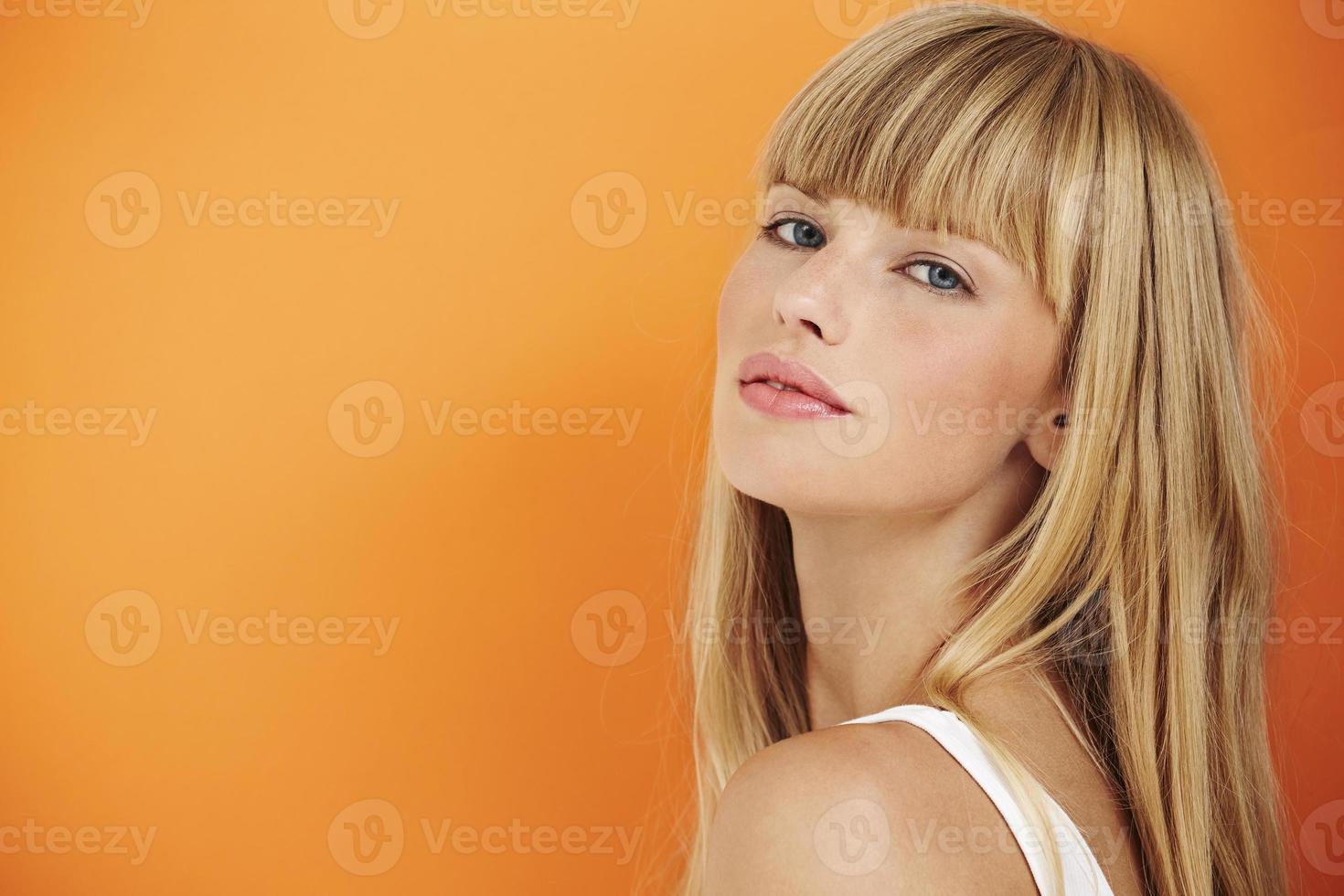Stunning young woman on orange photo