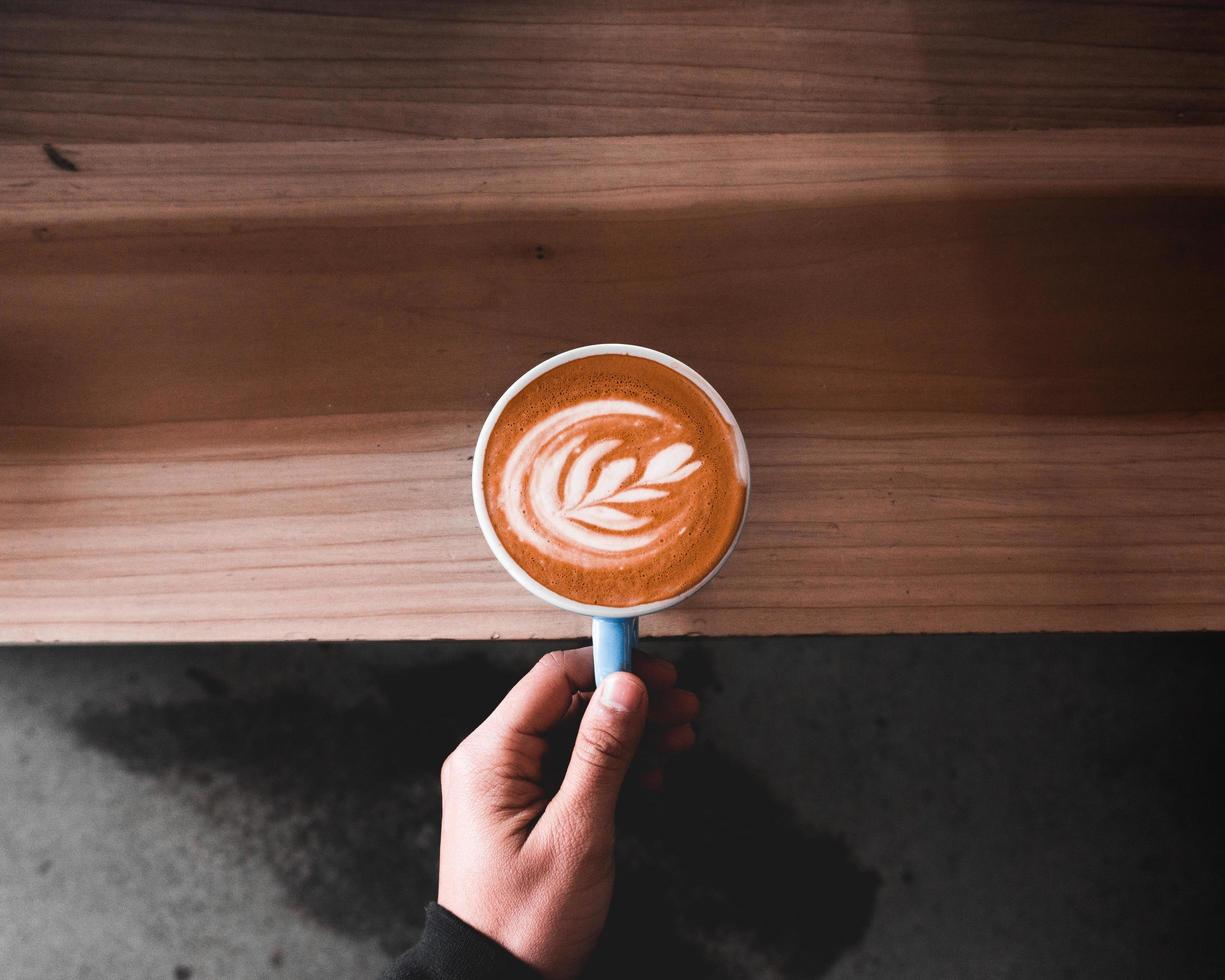 Person holding cappuccino latte photo