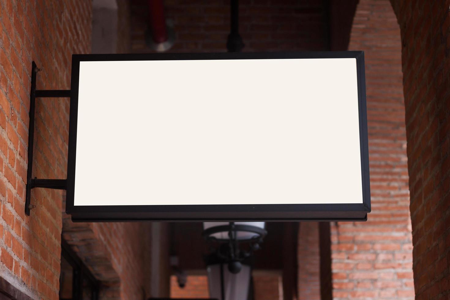 White signboard on brick wall photo