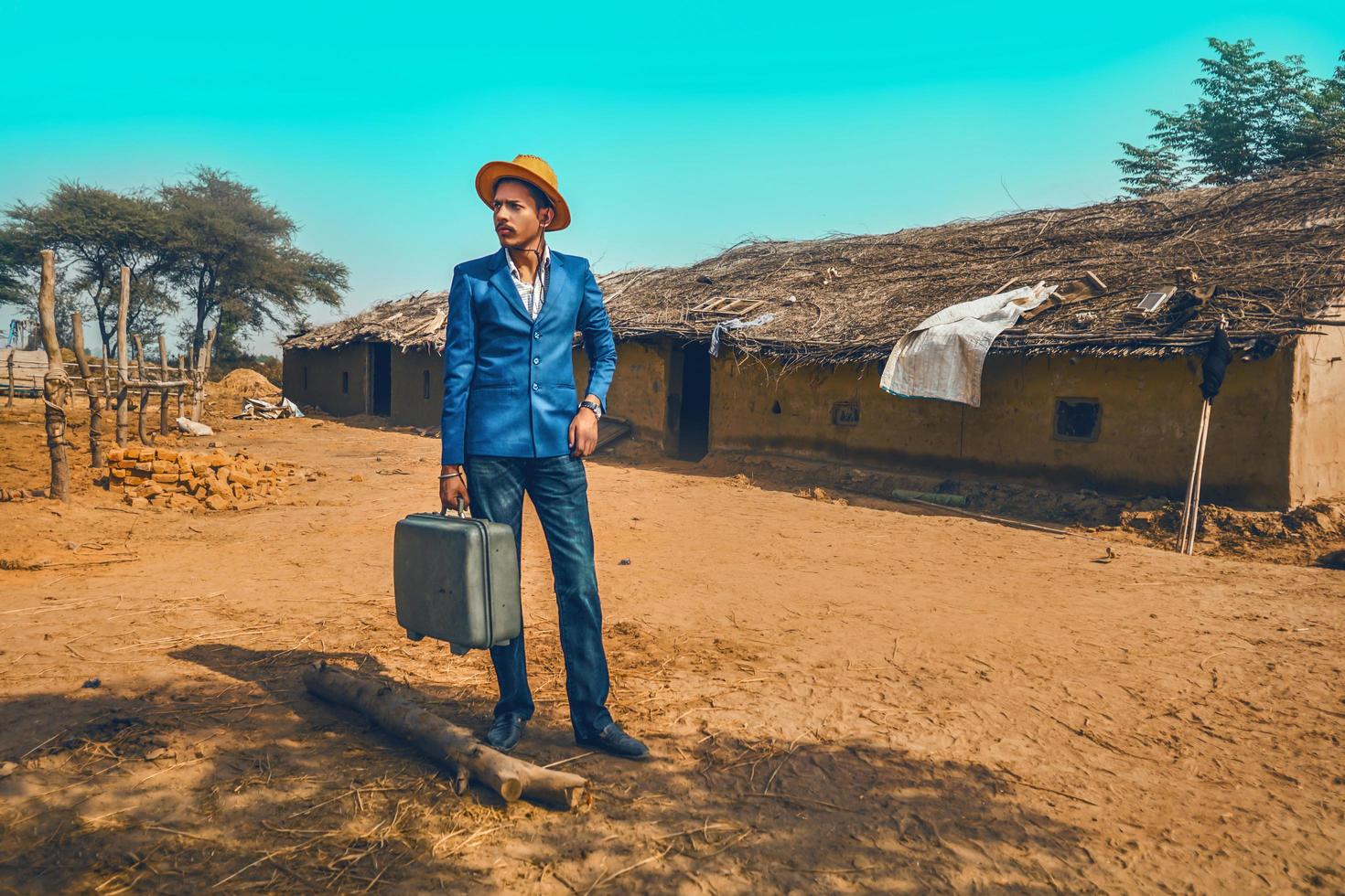 Man with suitcase next to house photo