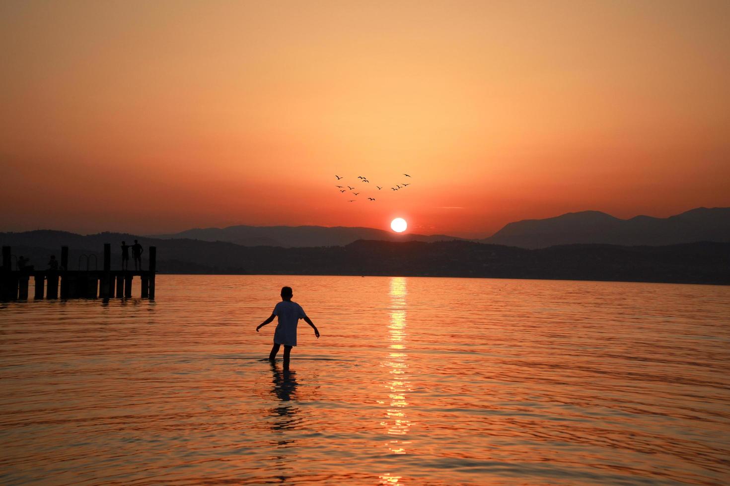 hombre caminando en el mar bajo la hora dorada foto