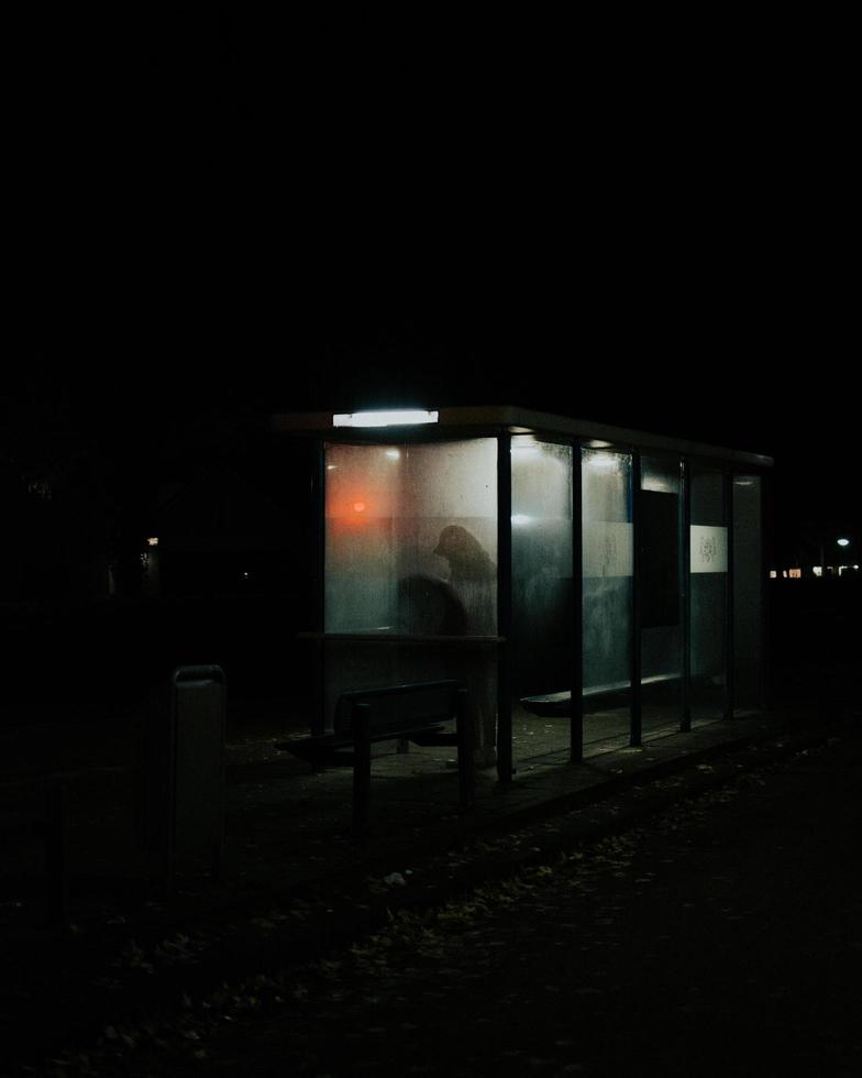 Silhouette of person at bus stop photo