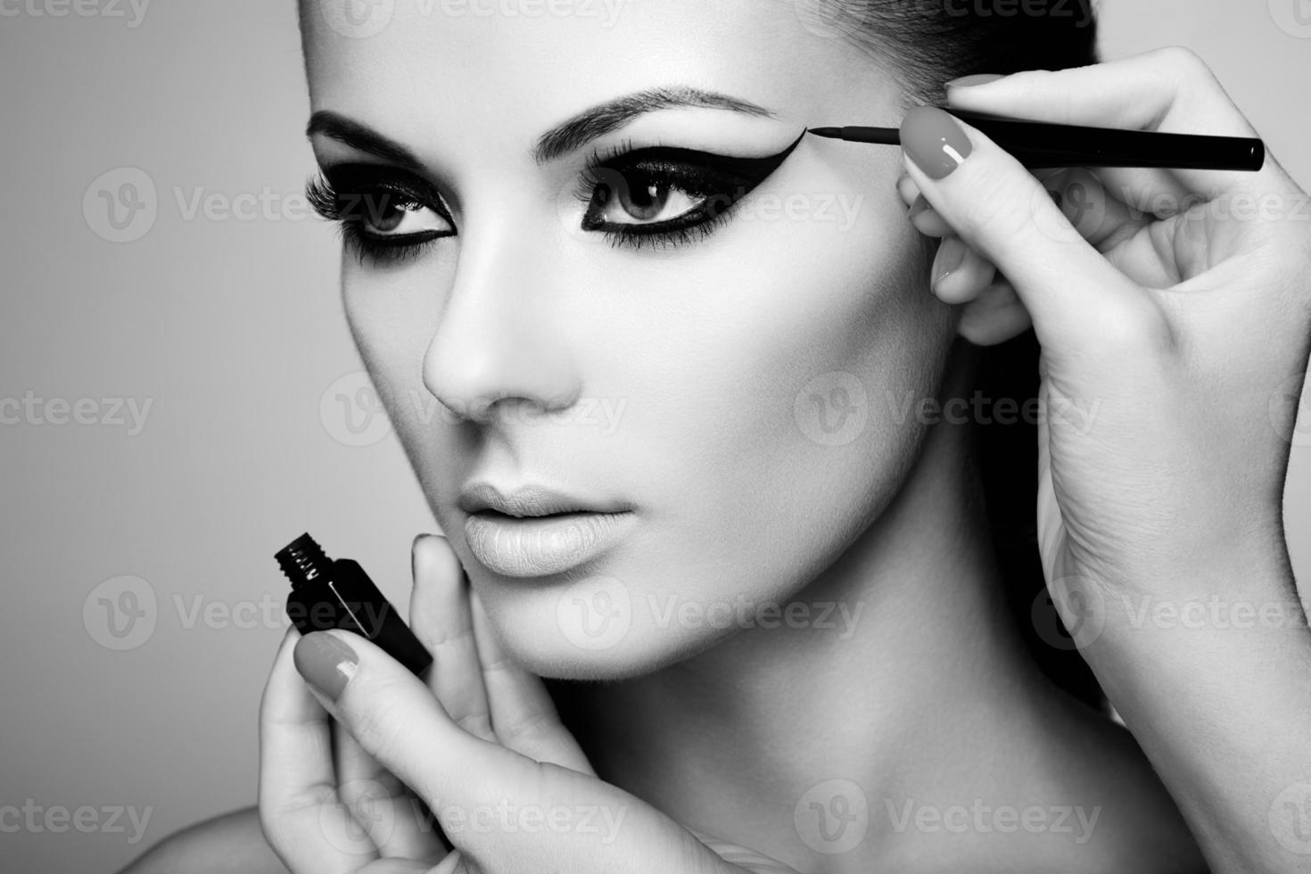 Makeup artist applies eye shadow photo