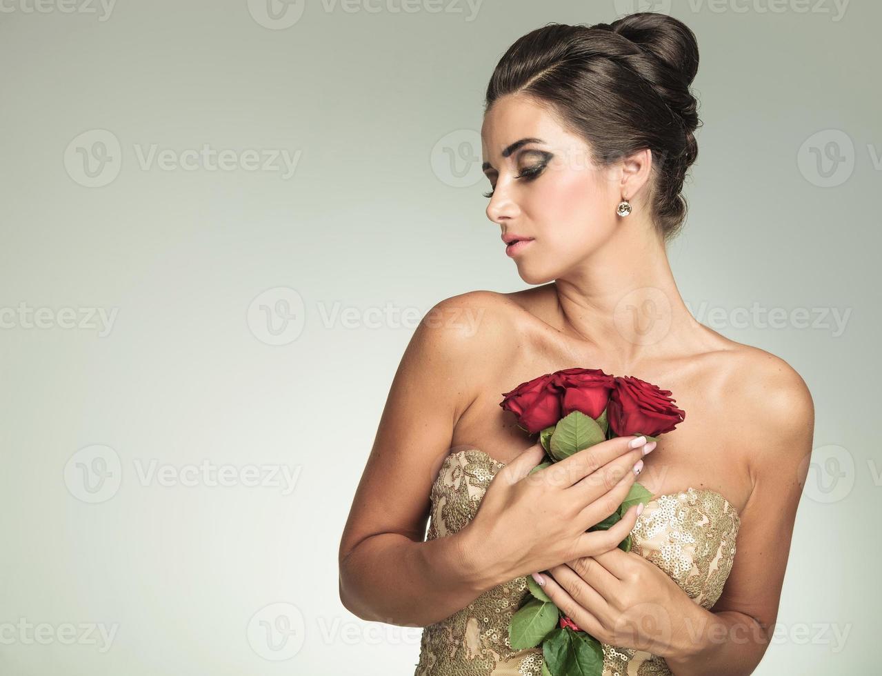 mujer sosteniendo rosas en su pecho y mira a un lado foto