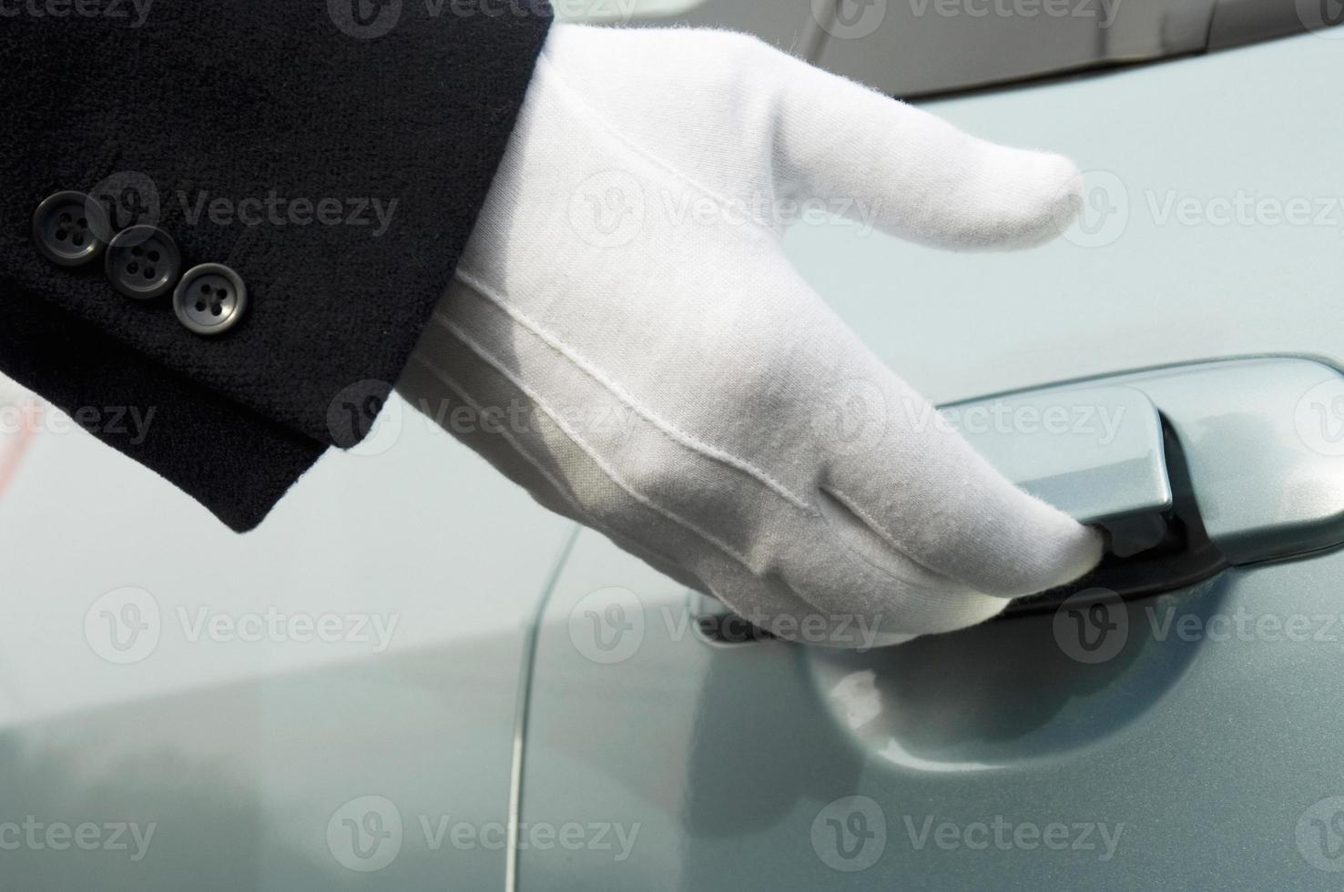 White formal gloved uniformed hand opening car door photo