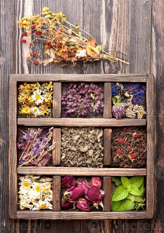 Hierbas medicinales secas y flores en una caja de madera. foto
