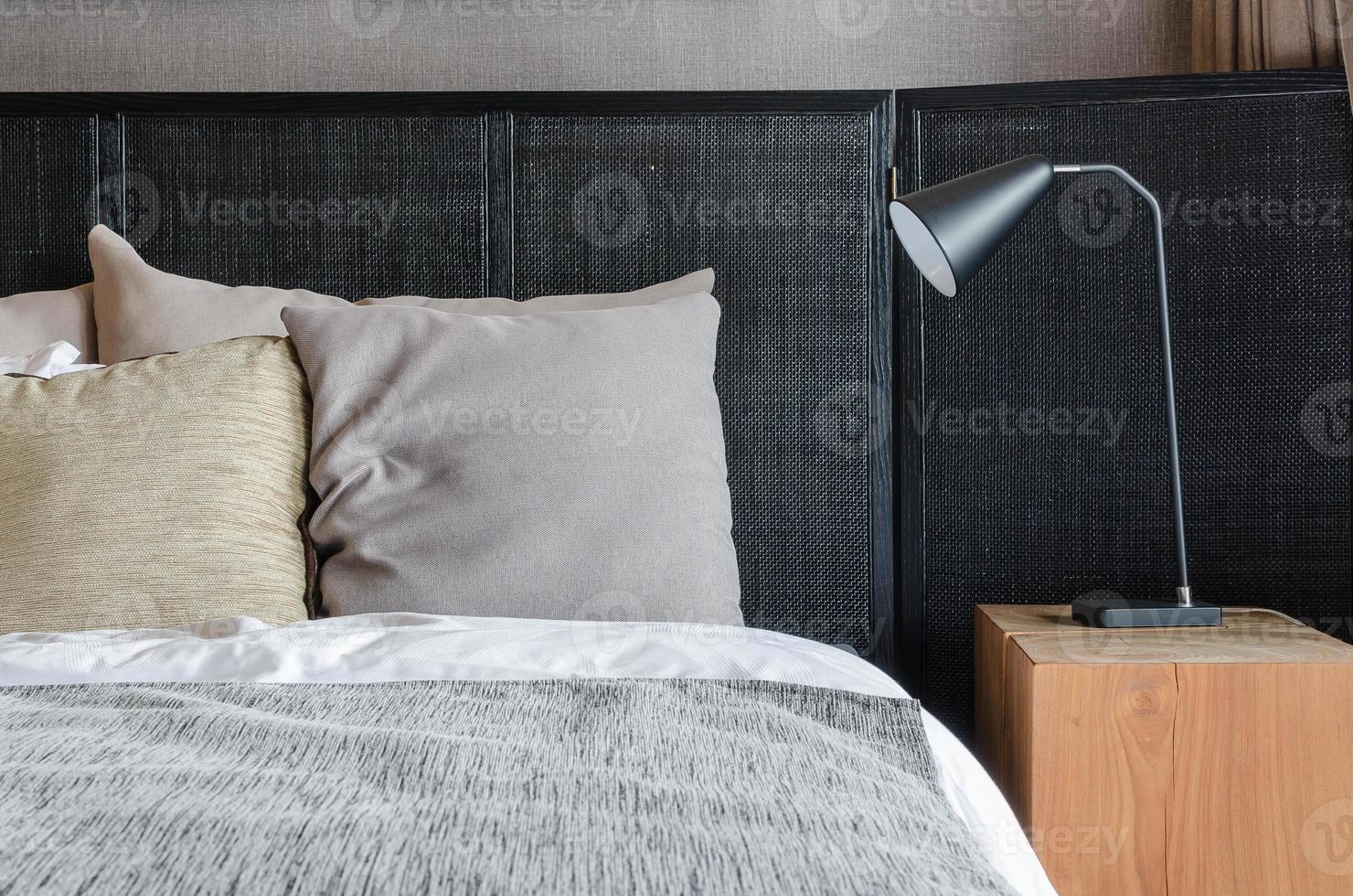 Lámpara negra moderna sobre mesa de madera en el dormitorio foto