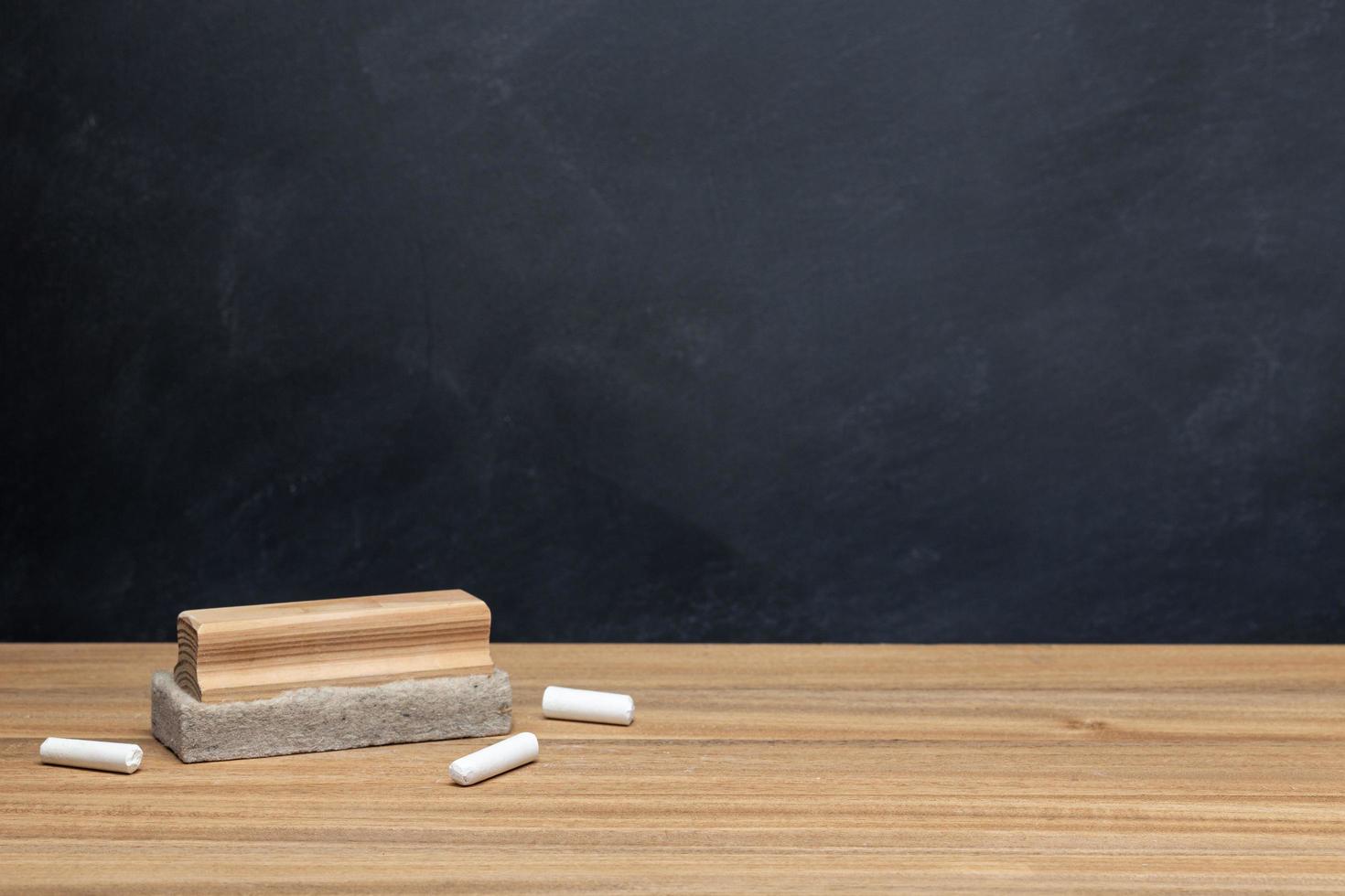 Chalk and eraser on wooden desk  photo