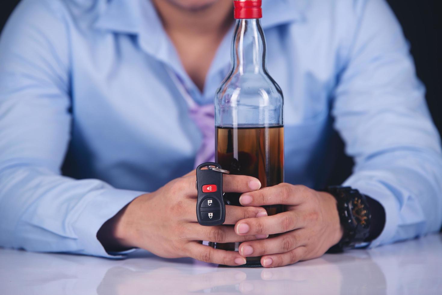 hombre con una botella de cerveza y una llave de coche foto