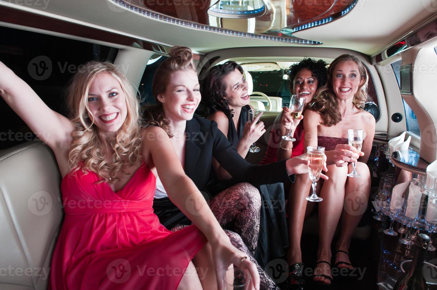 cinco chicas en una limusina bebiendo y de fiesta foto