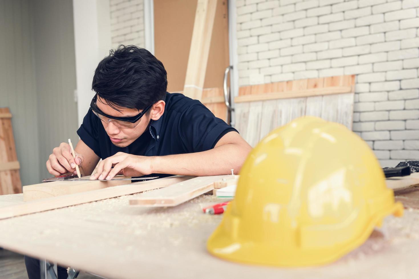 Carpenter Man is Working Timber Woodworking in Carpentry Shophouse, Craftsman is Measuring Timber Frame for Wooden Furniture in Workshop. Workmanship and Job Occupation Concept photo