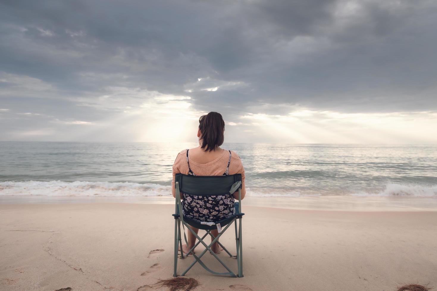 Freelancer woman is working on tablet facing the ocean photo