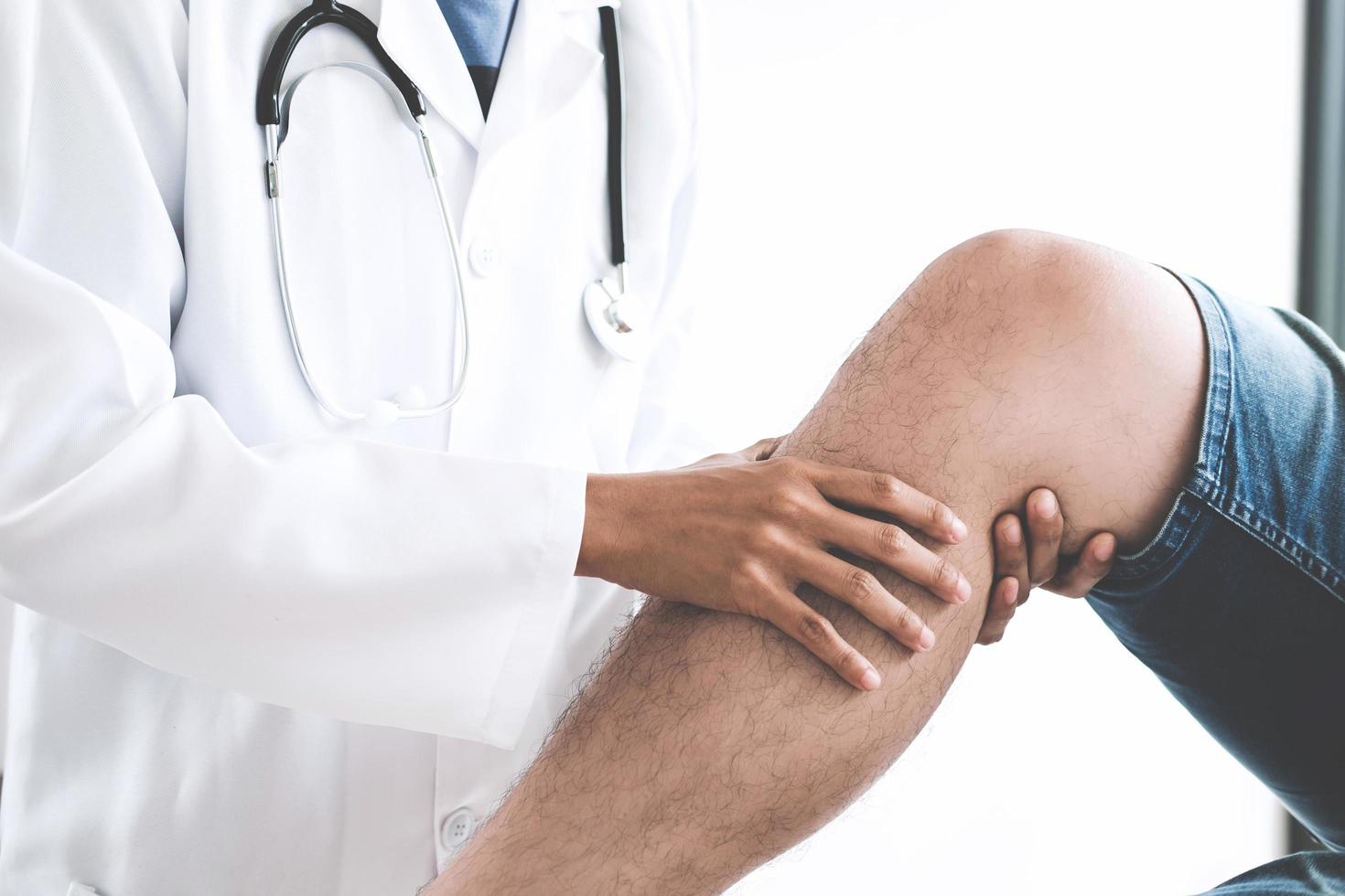 Doctor checking patient's knees  photo