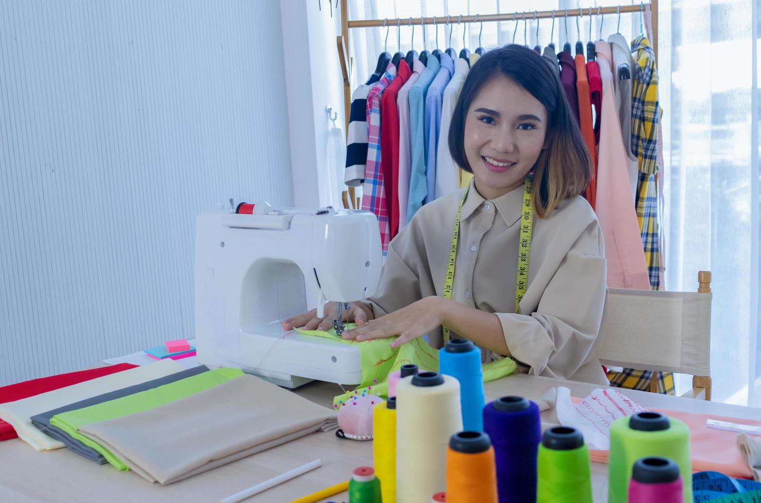 mujer diseñador de moda cosiendo ropa foto