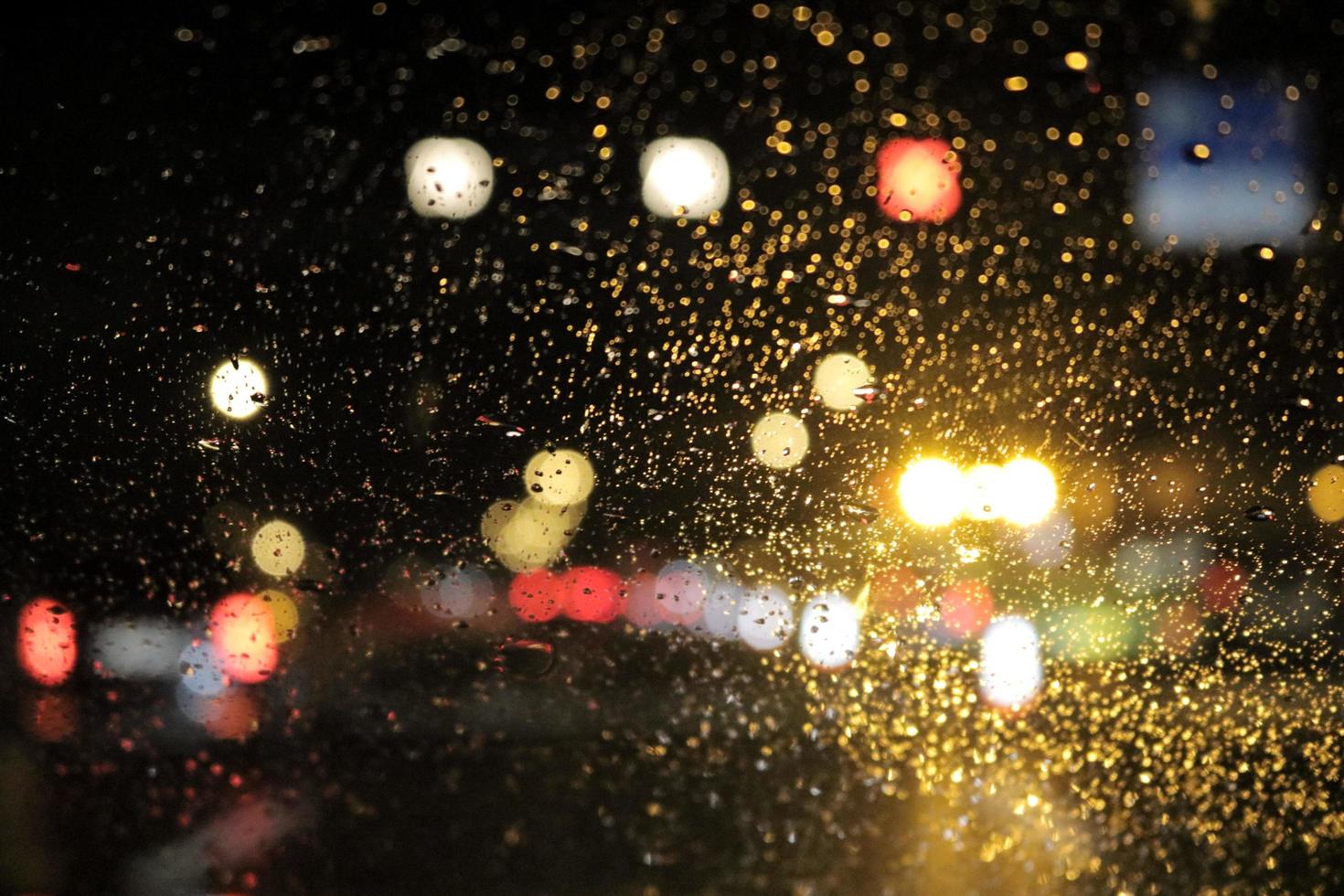 gotas de lluvia en el parabrisas por la noche foto