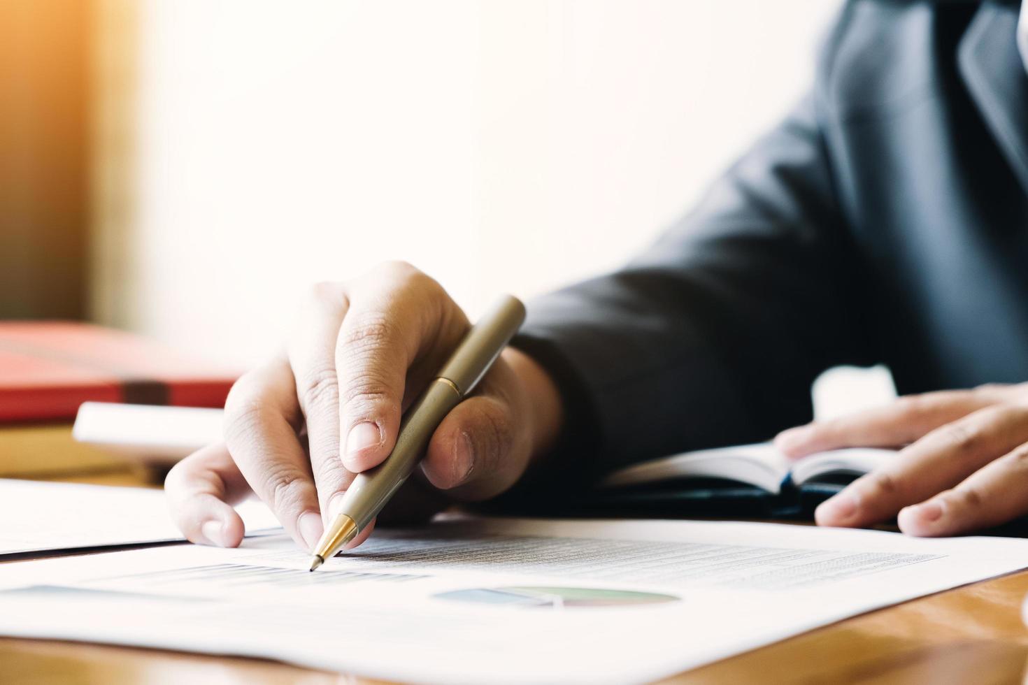 Close up of businessman writing on report photo