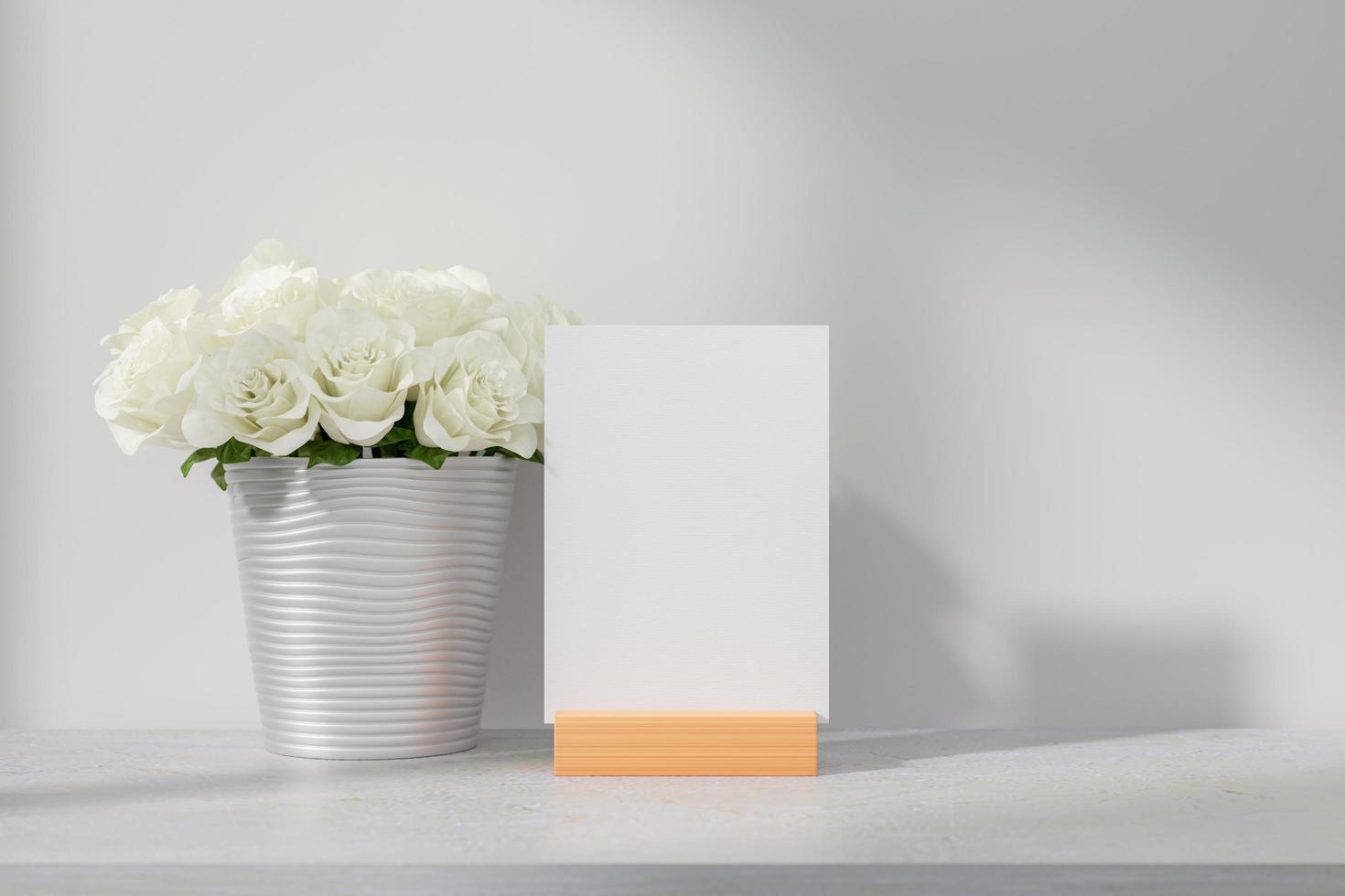 maqueta de tarjeta de felicitación de pie sobre la mesa con rosas blancas foto