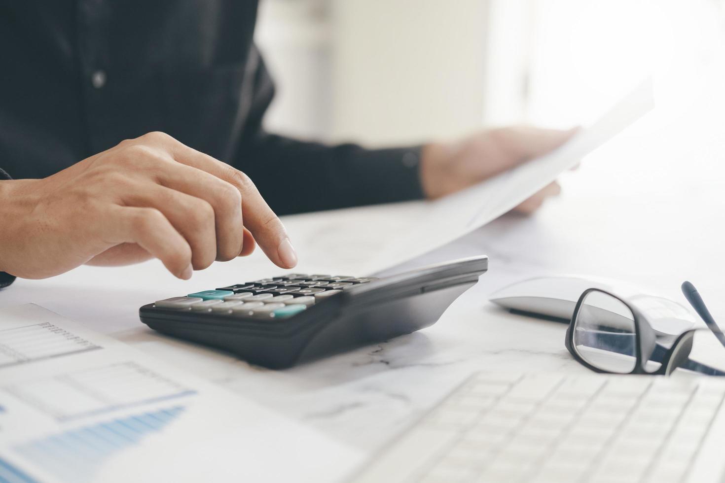 Close-up of man using calculator photo