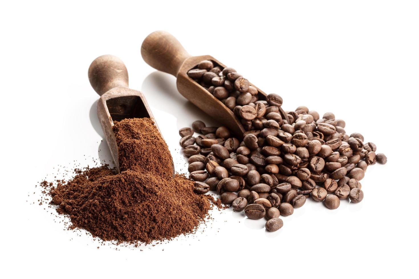 Two wooden scoops with ground and whole bean coffee photo