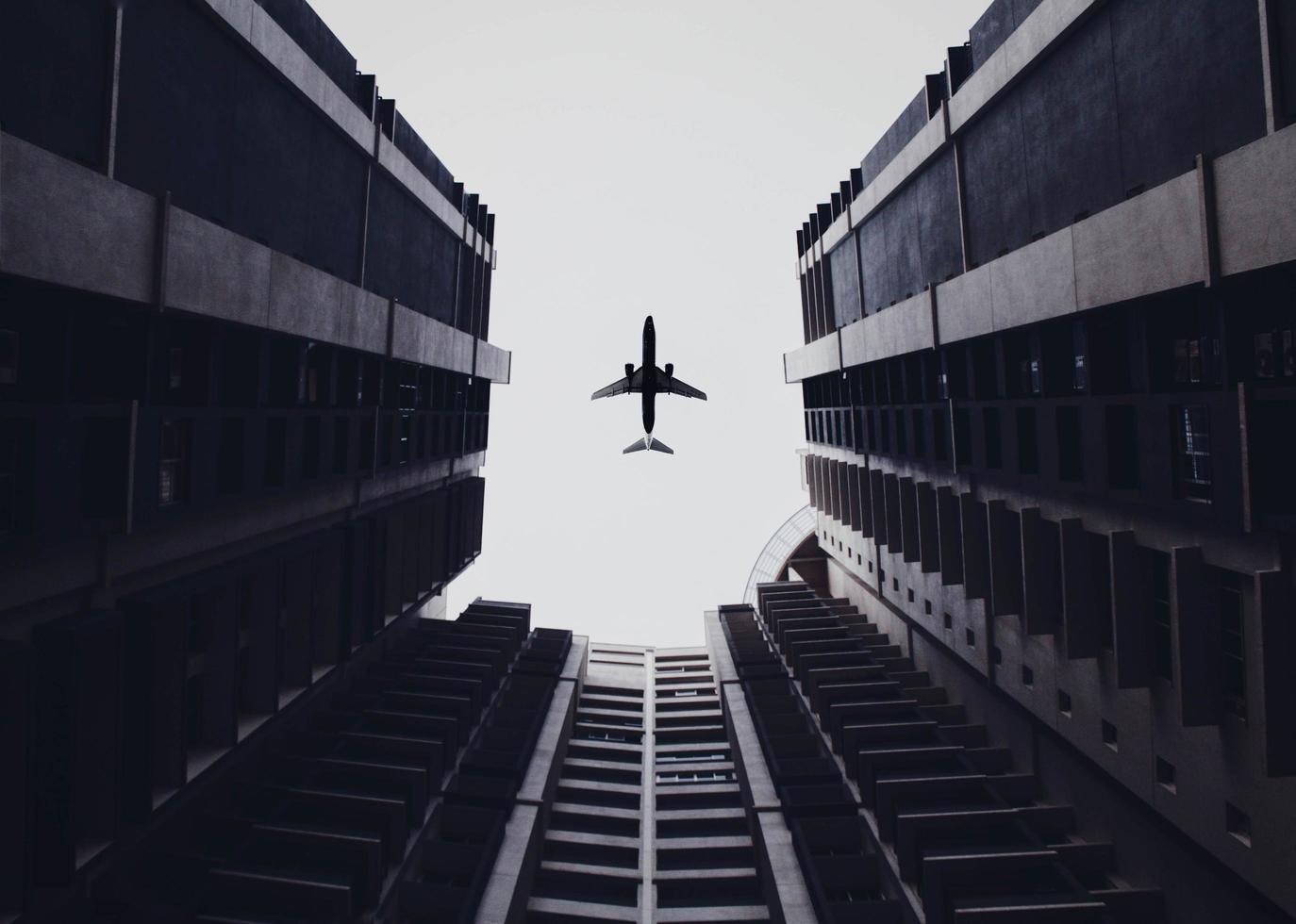 Low angle photo of airliner and buildings