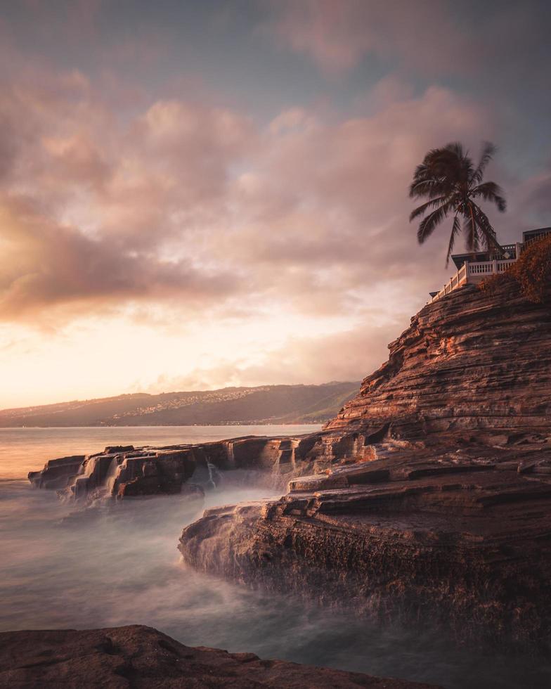 Cliff and ocean at sunset photo