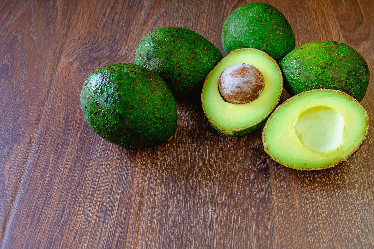 Avocadoes on wooden background photo