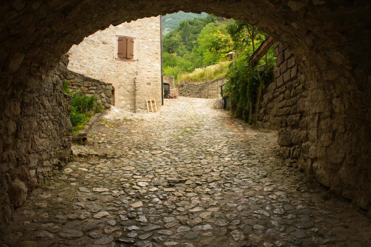 arco medieval y calle adoquinada foto