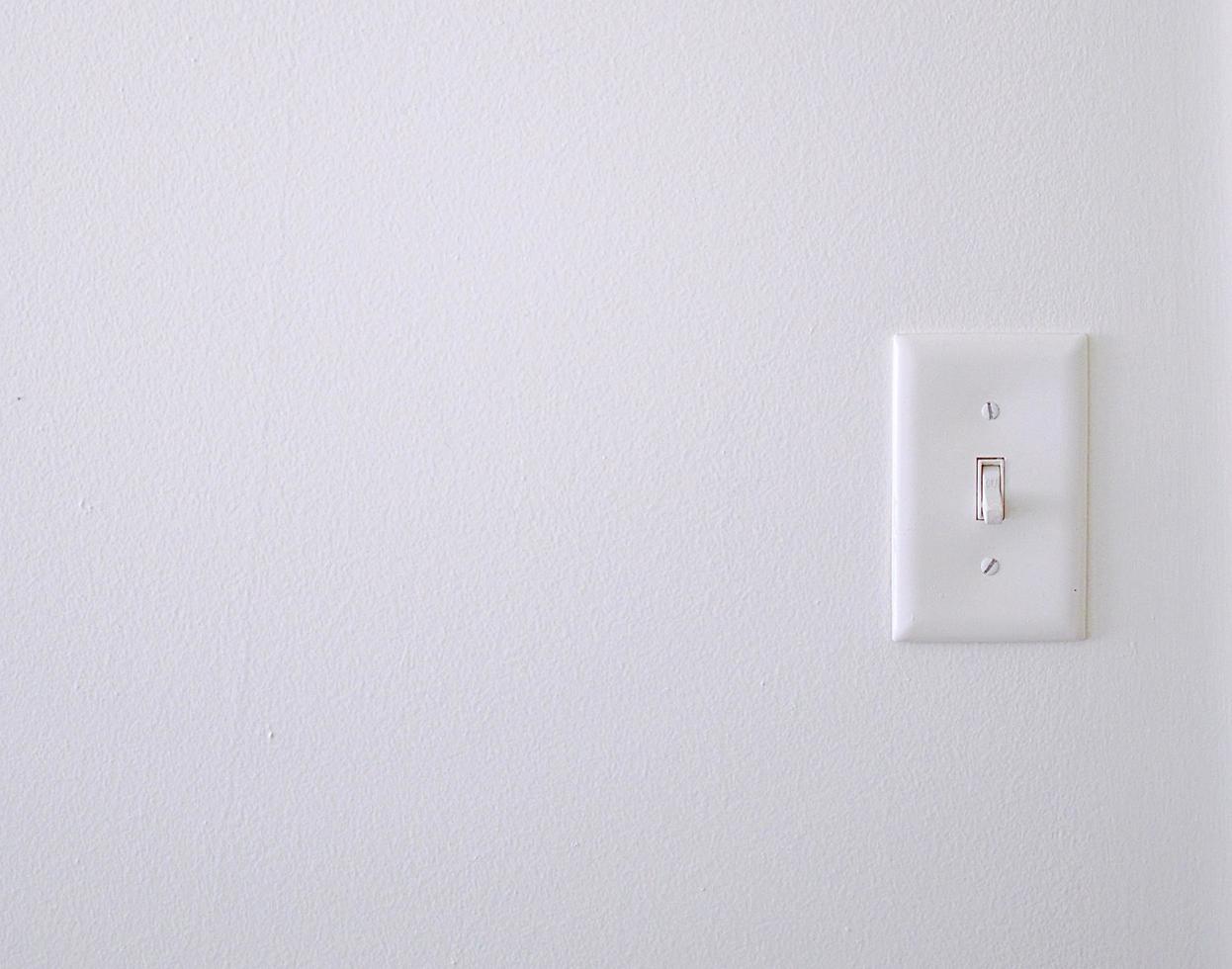 Un interruptor de luz blanca en una pared.