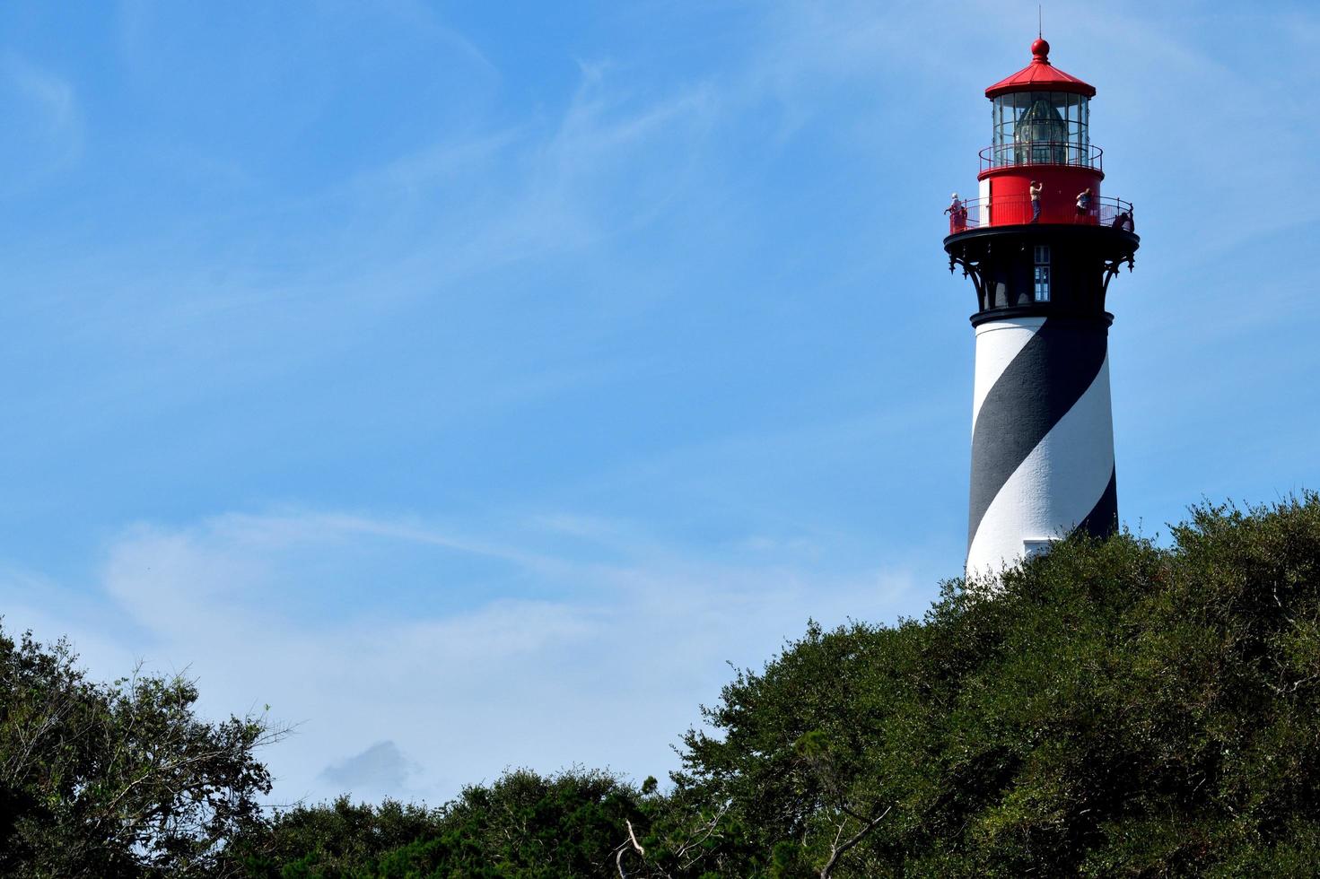 Historic lighthouse behind the trees photo