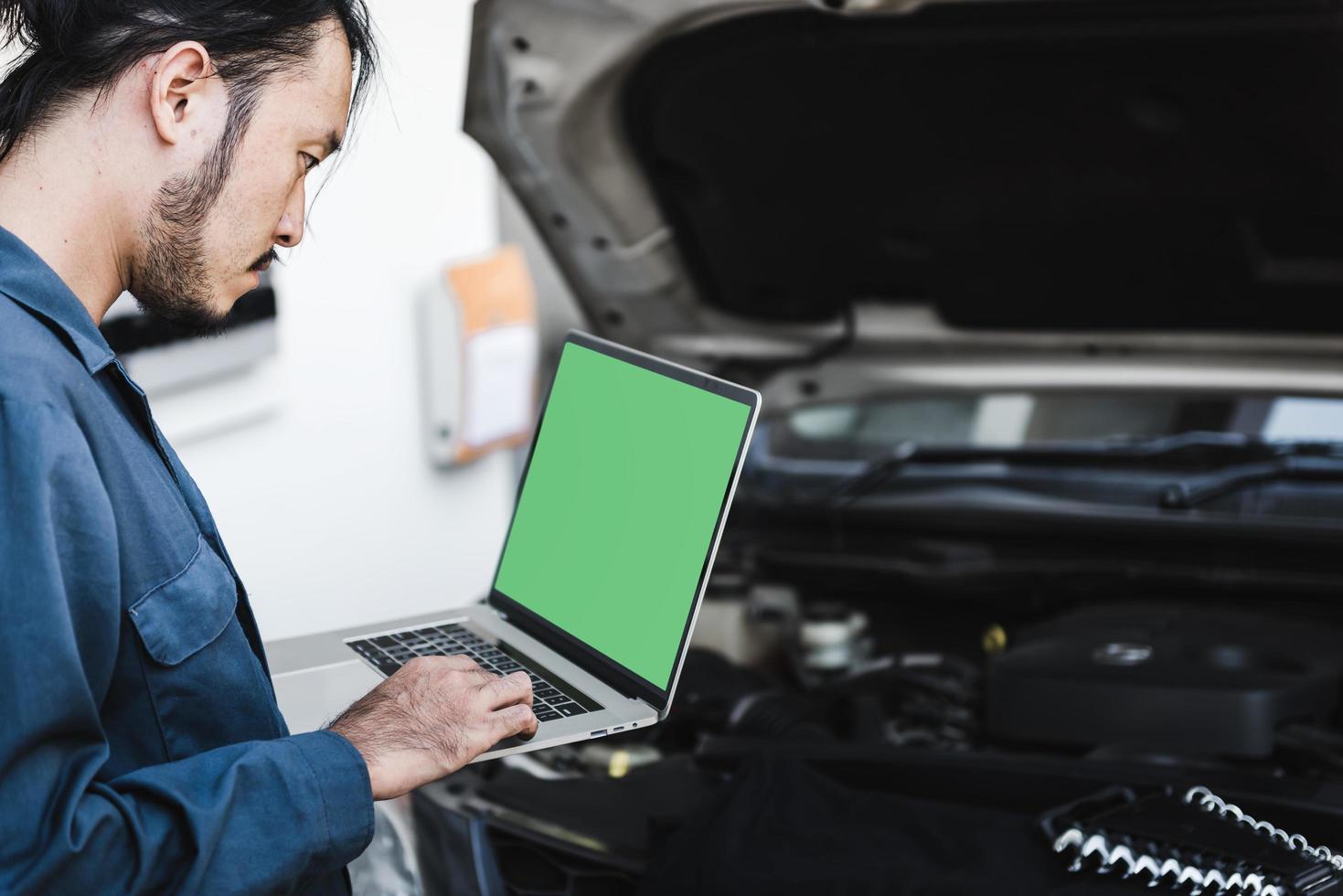 mecánico de automóviles comprobando el costo de reparación foto