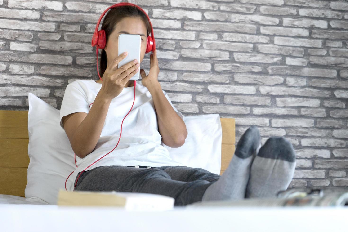 mujer relajante en la cama y escuchar música foto