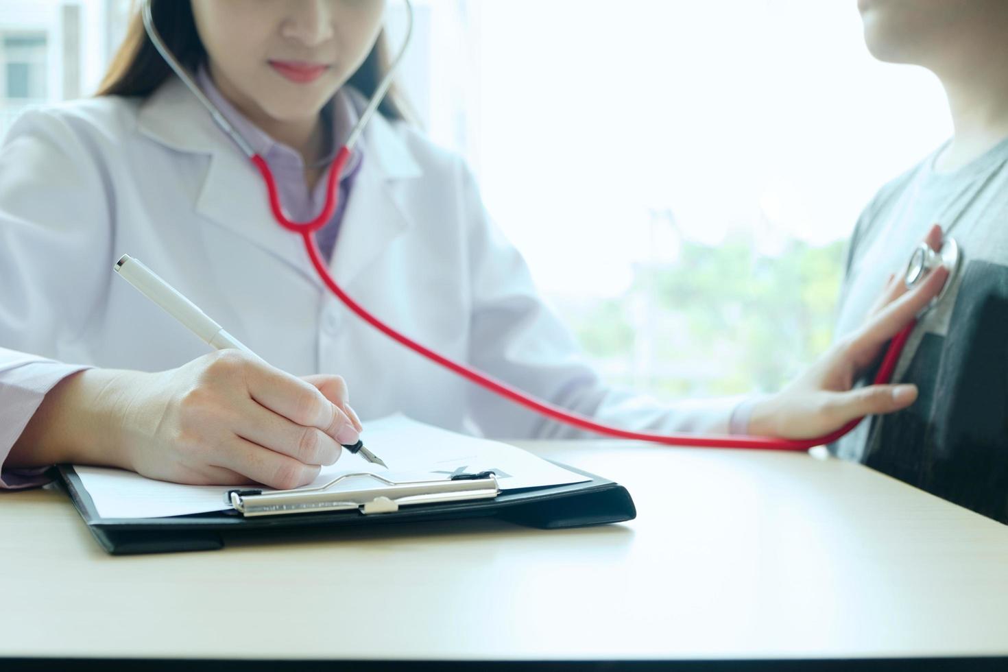 médico examina a un paciente con un estetoscopio foto