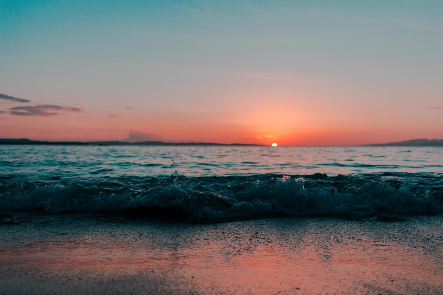 escena del océano durante la puesta de sol foto