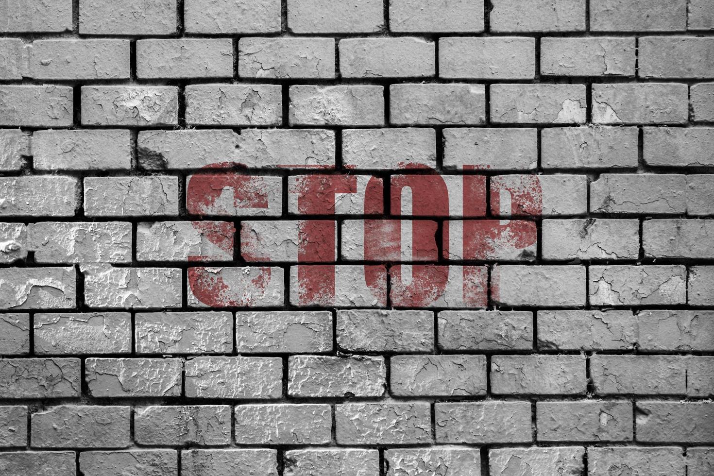 Stop painted on a brick wall photo