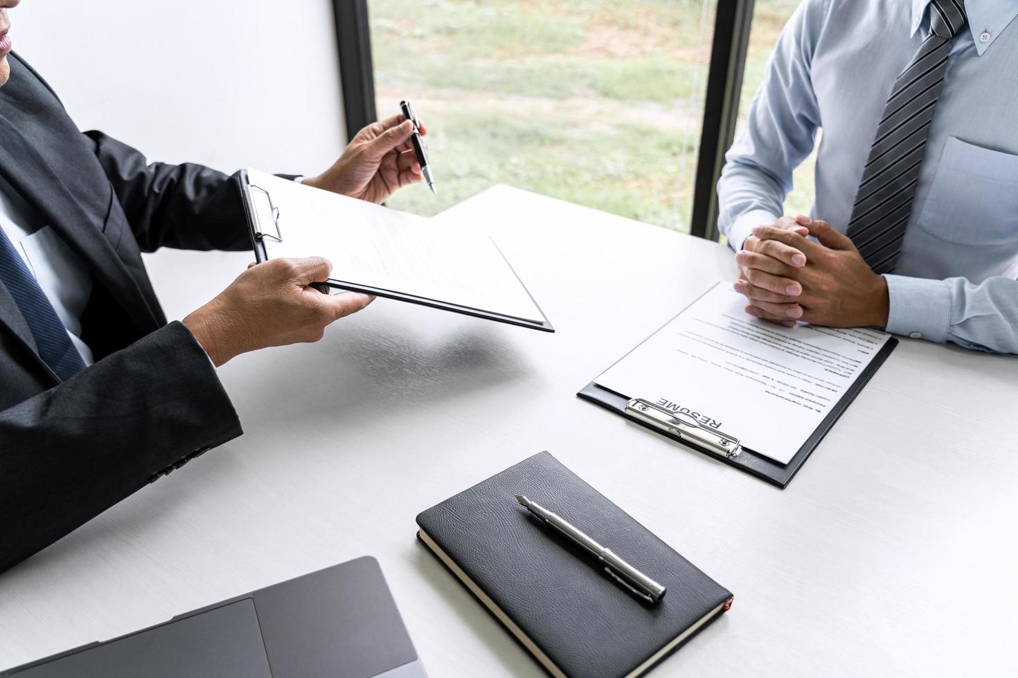 Gerente senior del comité leyendo un currículum durante una entrevista de trabajo foto