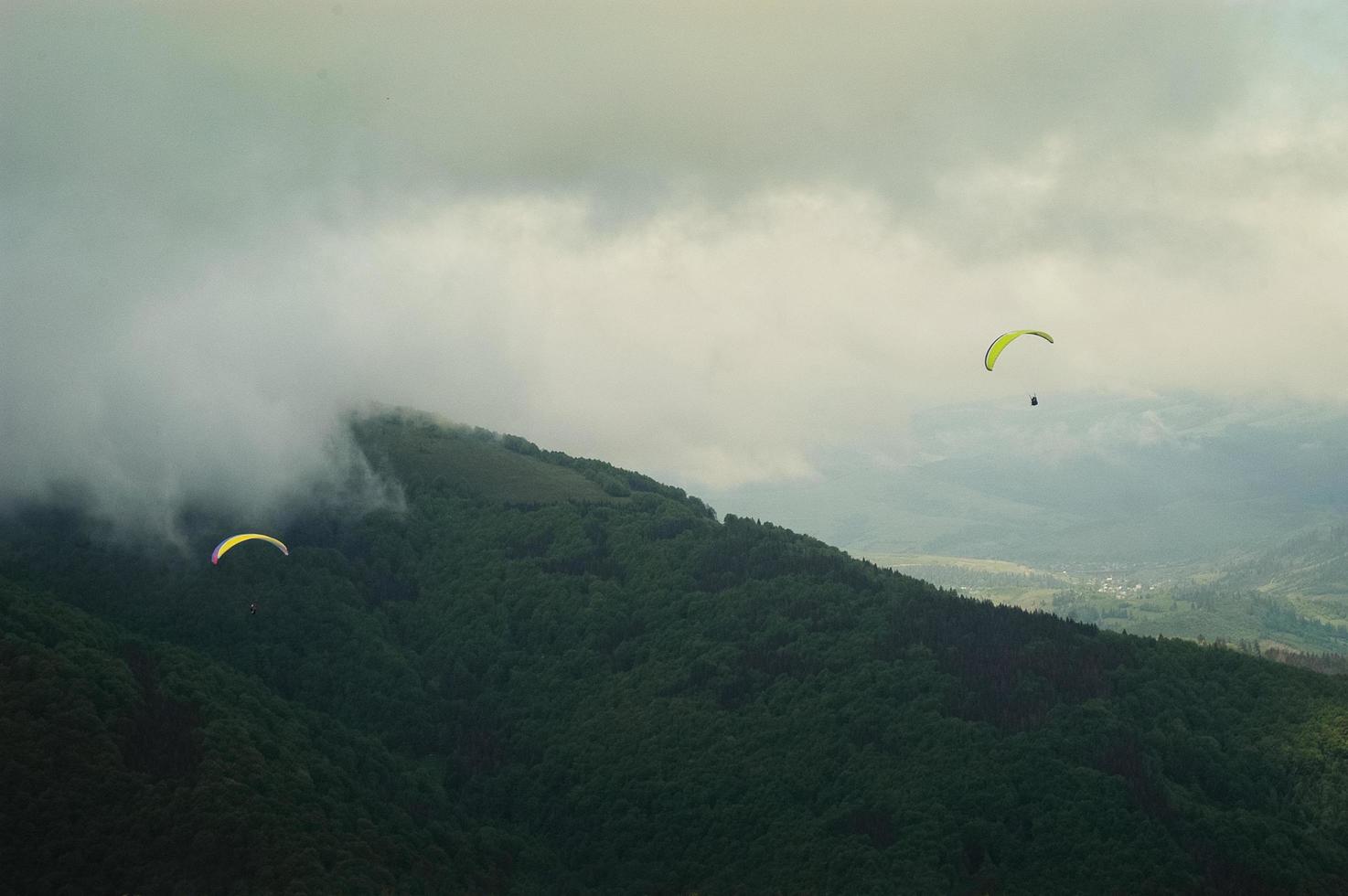 Saltadores de paracaidista en montañas neblinosas nubladas foto